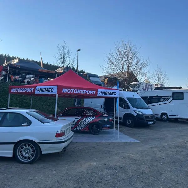 Červený stan Motorsport Němec v servisní zóně, pod ním BMW M3 E36