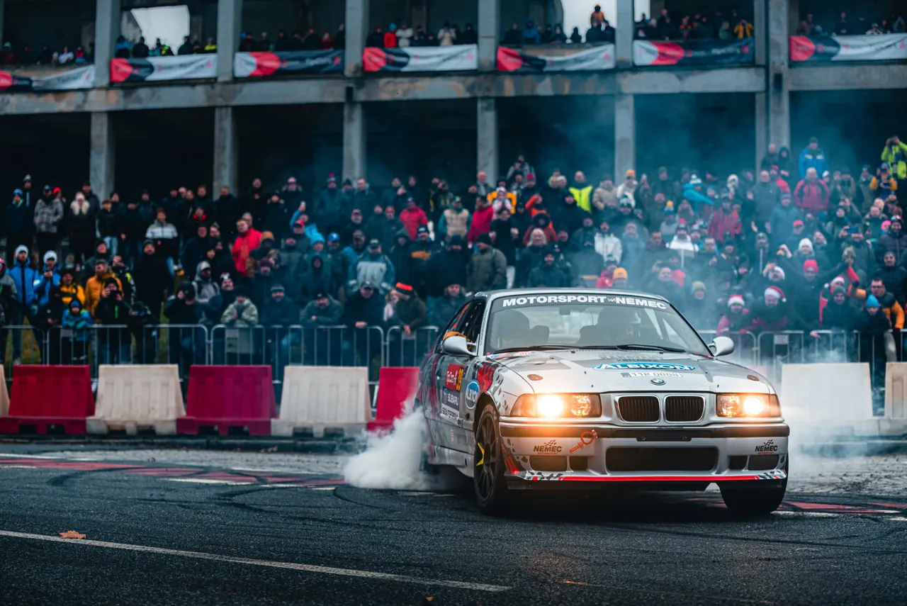 Stříbrné BMW M3 E36 týmu Motorsport Němec projíždí rychlostní zkoušku před plnou tribunou diváků